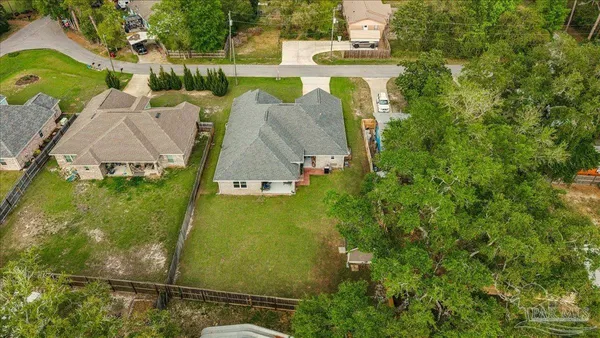 an aerial view of residential houses with outdoor space and trees
