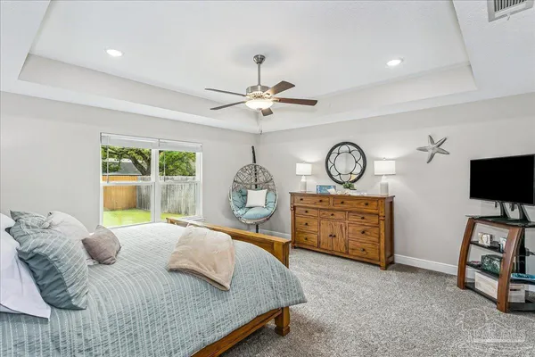 a bedroom with a bed a flat screen tv and a large window with the garden view