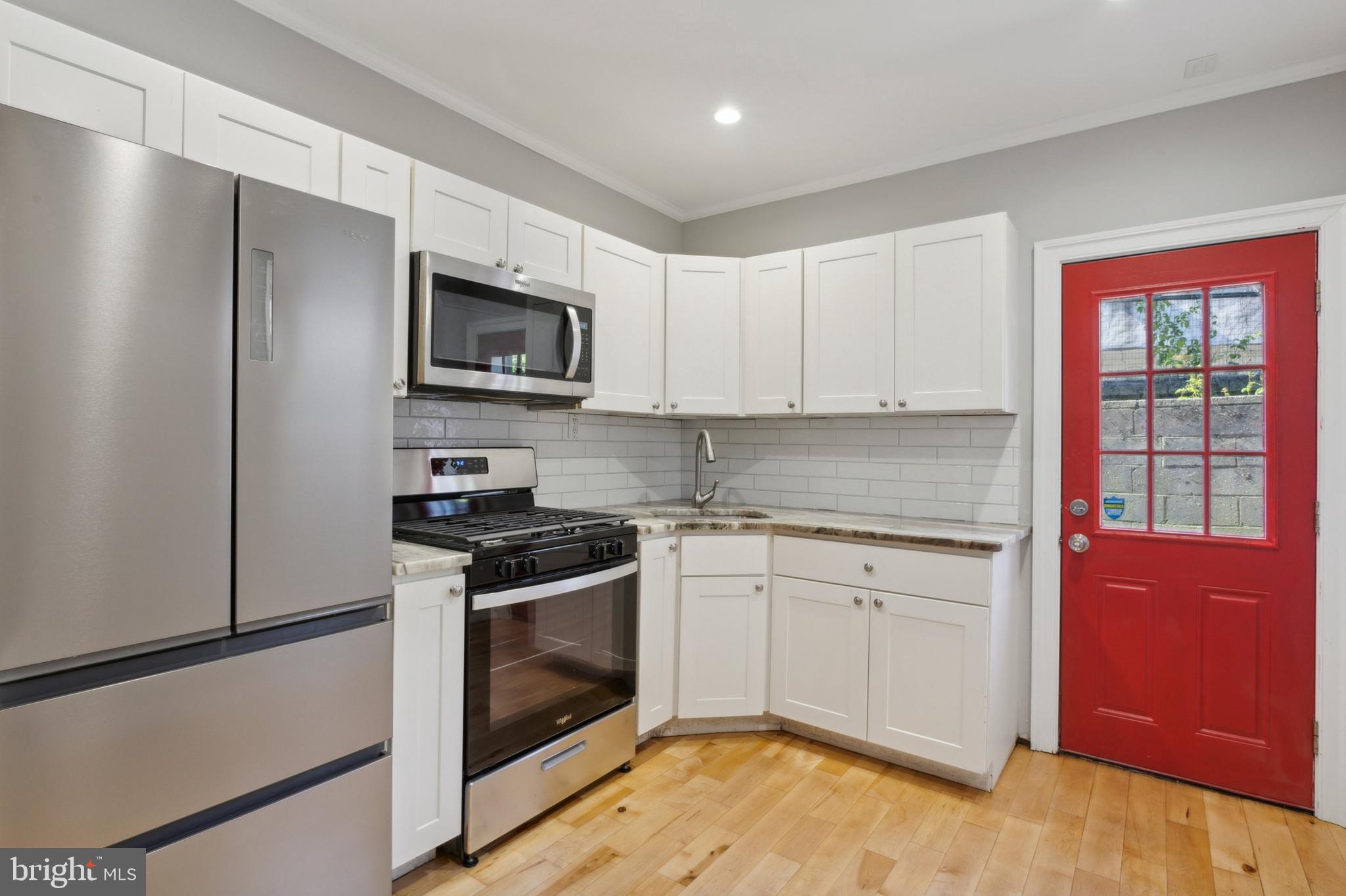 a kitchen with granite countertop wooden cabinets stainless steel appliances and a window