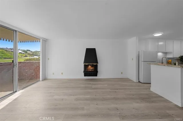 a view of a big room with wooden floor and windows