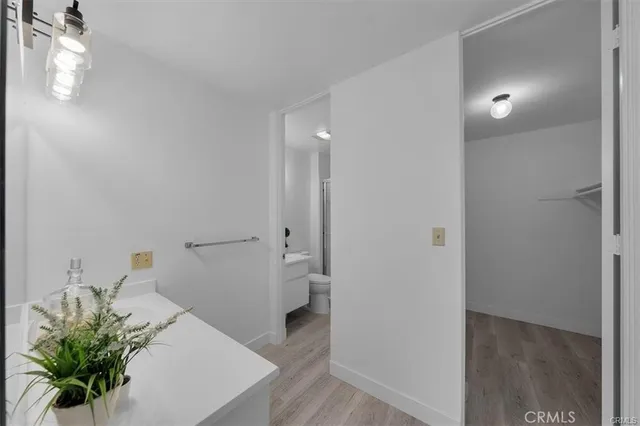 a view of a hallway to a room with wooden floor