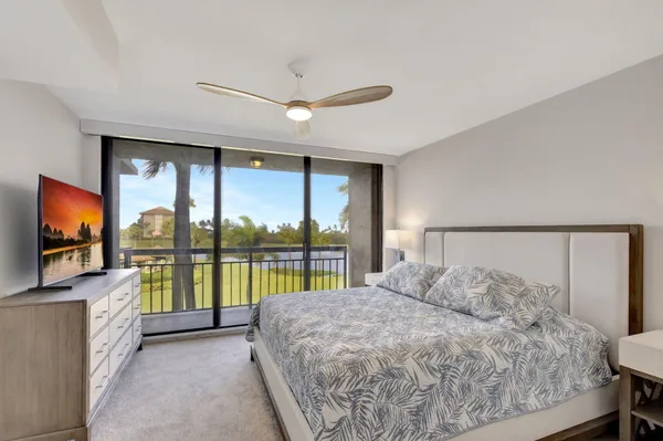 a bed room with a bed and a flat tv screen on dresser