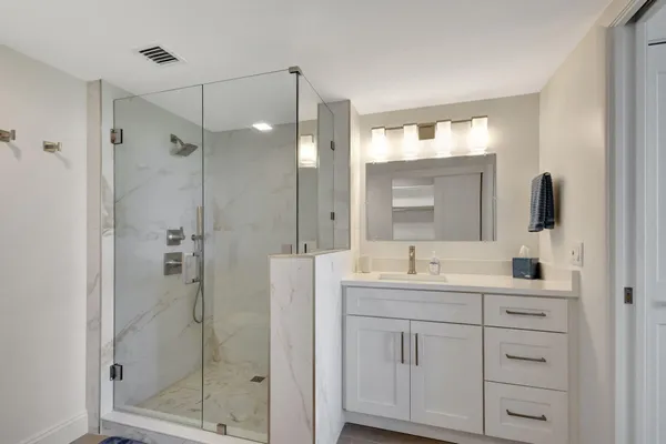 a bathroom with a double vanity sink mirror and shower