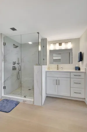 a bathroom with a shower a sink and mirror