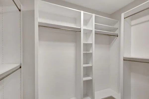 a view of walk in closet with empty racks