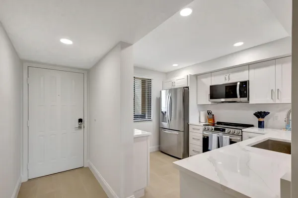 a kitchen with stainless steel appliances kitchen island a refrigerator sink and microwave