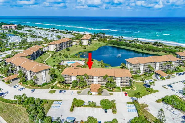 an aerial view of residential houses with outdoor space and ocean view