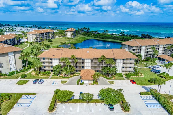 an aerial view of residential houses with outdoor space and ocean view