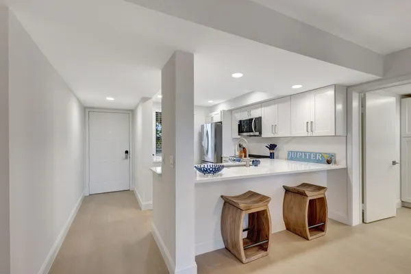 a view of kitchen with kitchen island stainless steel appliances refrigerator stove microwave and cabinets