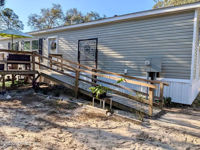 a view of a house with a yard and wooden fence