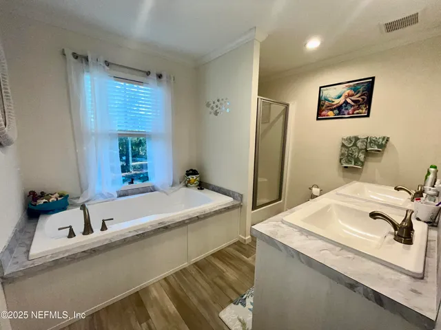a bathroom with a tub sink and mirror