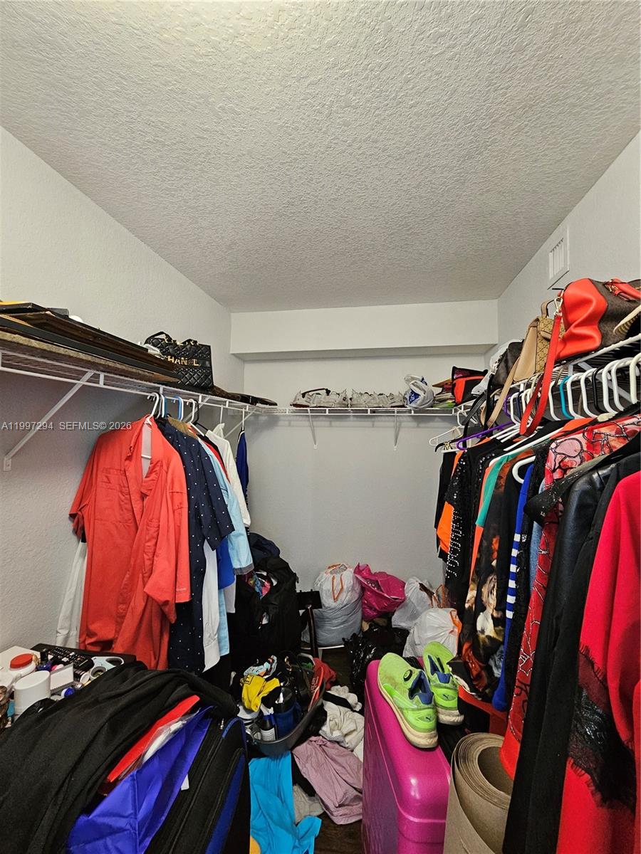 15470 Southwest 284th Street, Unit 3201 Homestead, FL 33033 - Photo 13 of 16 a view of walk in closet with clothes and shoes