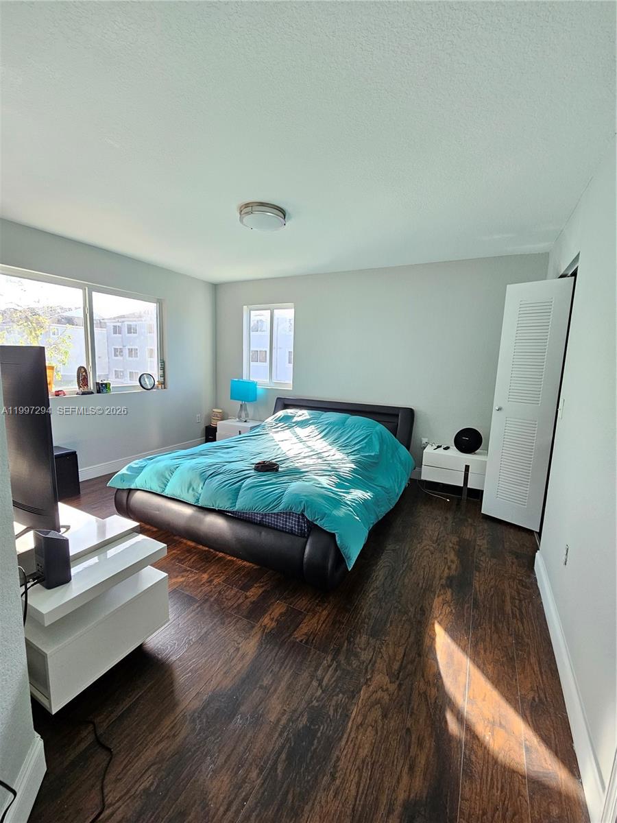 15470 Southwest 284th Street, Unit 3201 Homestead, FL 33033 - Photo 6 of 16 a bedroom with a bed and wooden floor