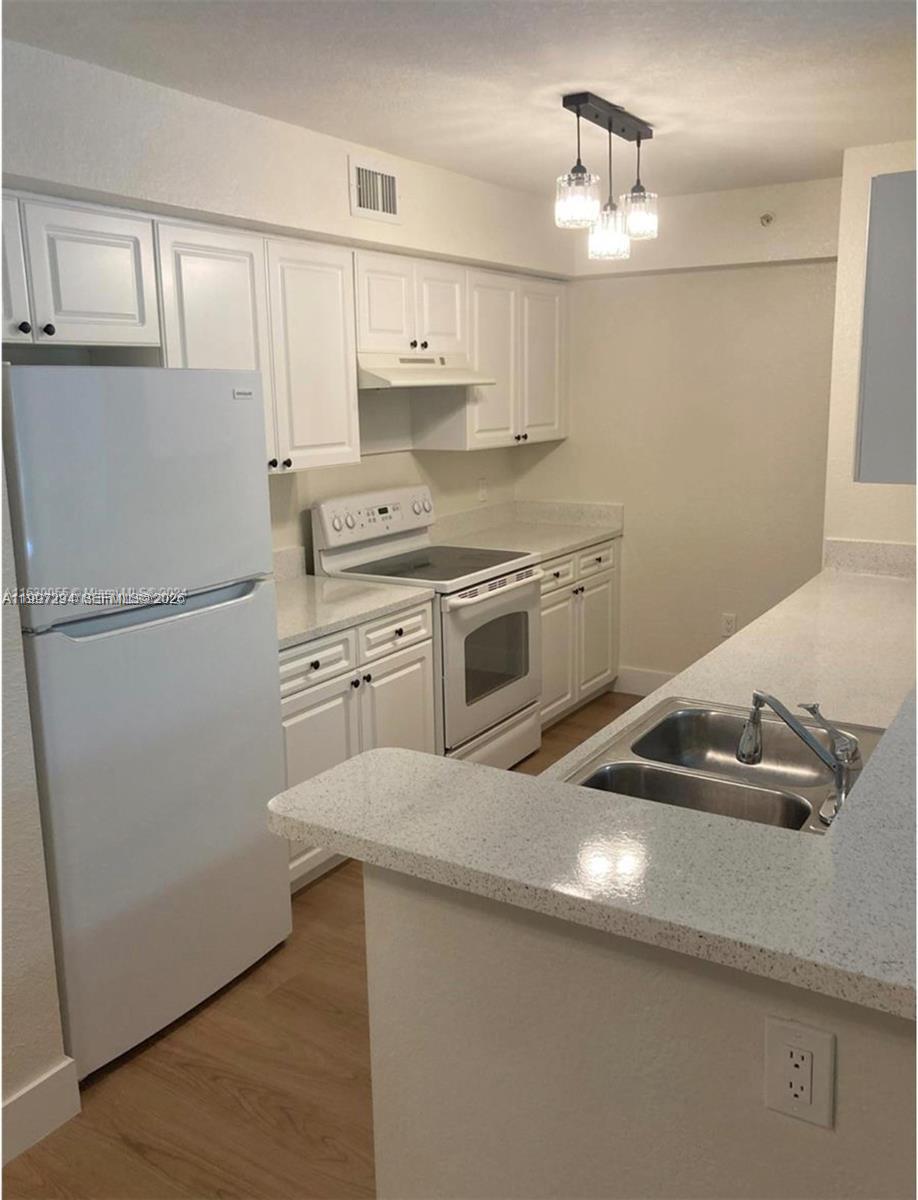 15470 Southwest 284th Street, Unit 3201 Homestead, FL 33033 - Photo 7 of 16 a kitchen with a sink a stove and refrigerator