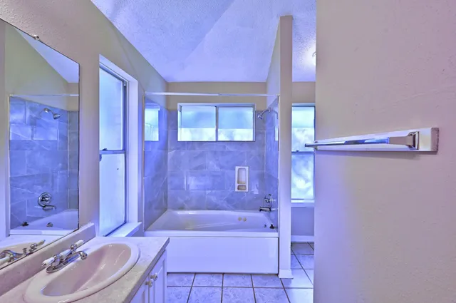 a bathroom with a granite countertop bathtub shower sink and toilet