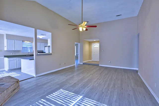 a view of a kitchen with wooden floor and a ceiling fan