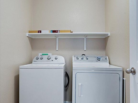 904 Lonesome Lilly Way Pflugerville, TX 78660 - Photo 30 of 34 Dedicated laundry area featuring a washer and dryer, with a white wall-mounted shelf above