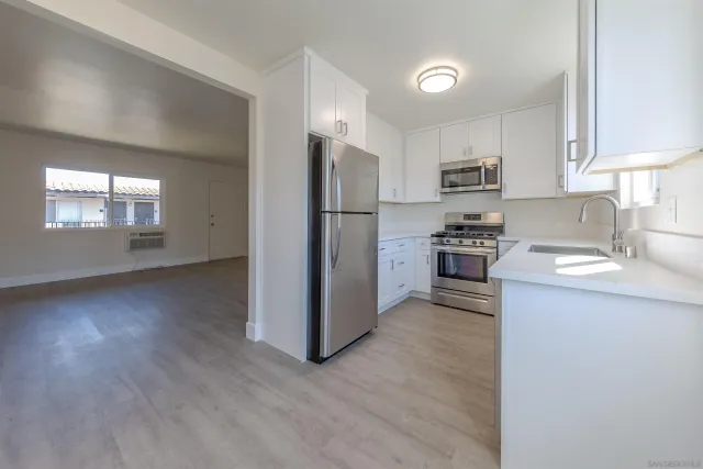 a kitchen with granite countertop a refrigerator and a sink