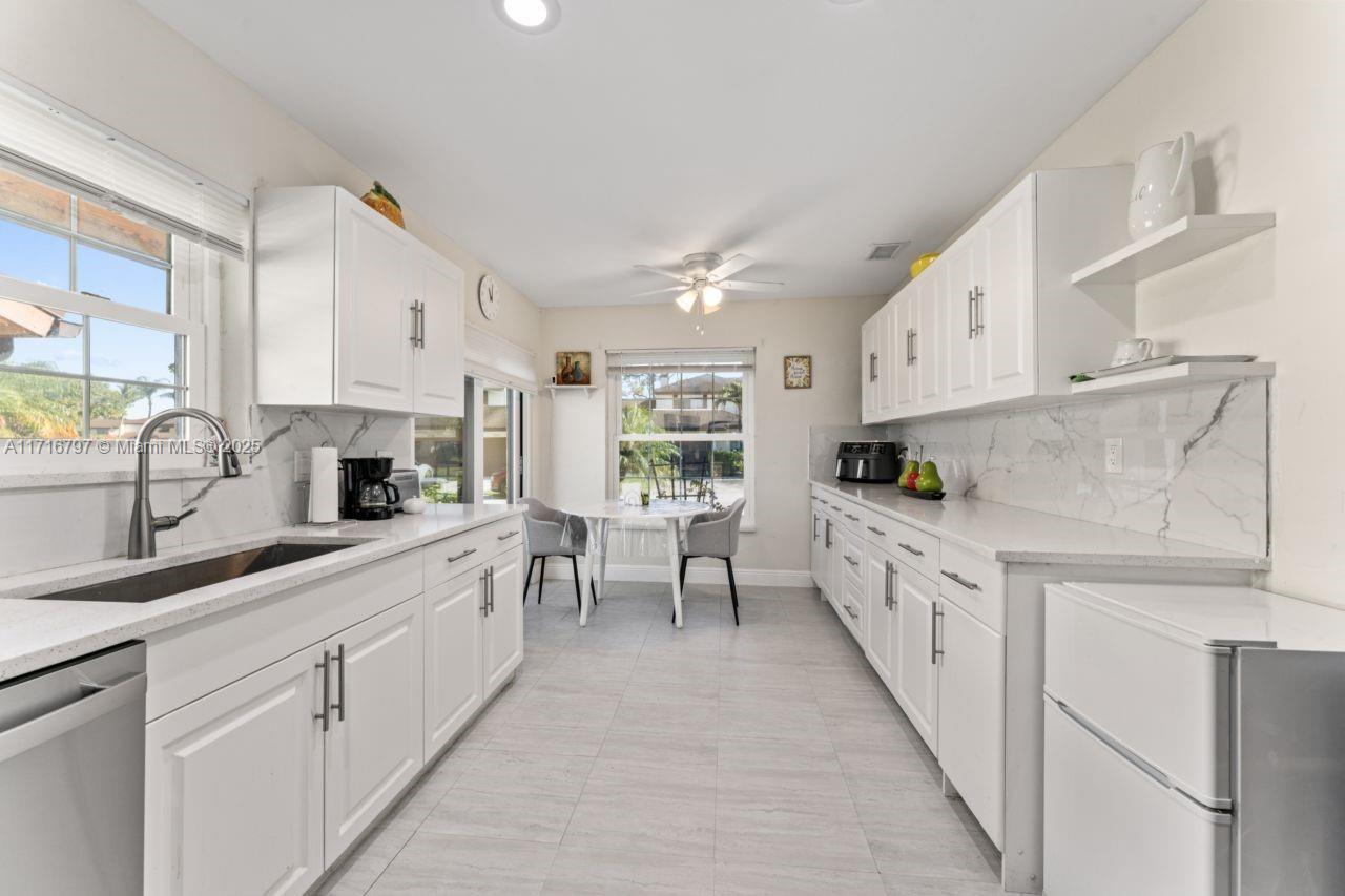 20929 Boca Ridge Drive West Boca Raton, FL 33428 - Photo 12 of 47 a kitchen with white cabinets and sink