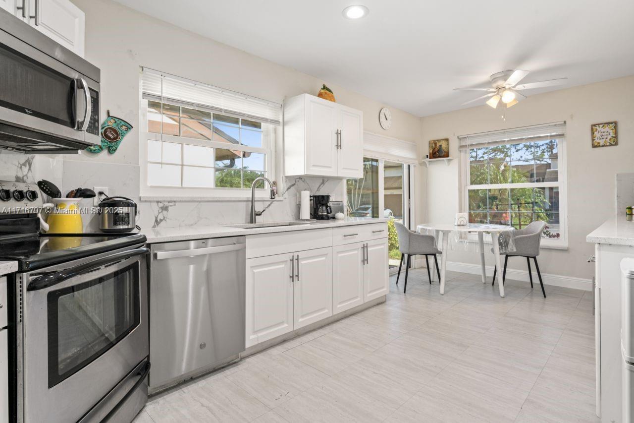20929 Boca Ridge Drive West Boca Raton, FL 33428 - Photo 15 of 47 a kitchen with stainless steel appliances granite countertop a stove a sink dishwasher and microwave oven with cabinets