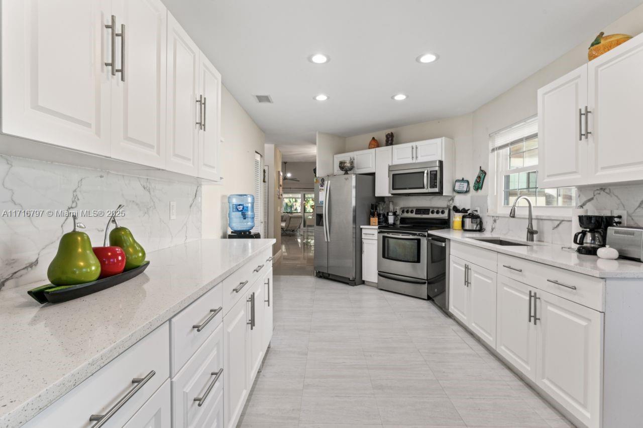 20929 Boca Ridge Drive West Boca Raton, FL 33428 - Photo 17 of 47 a kitchen with white cabinets and appliances