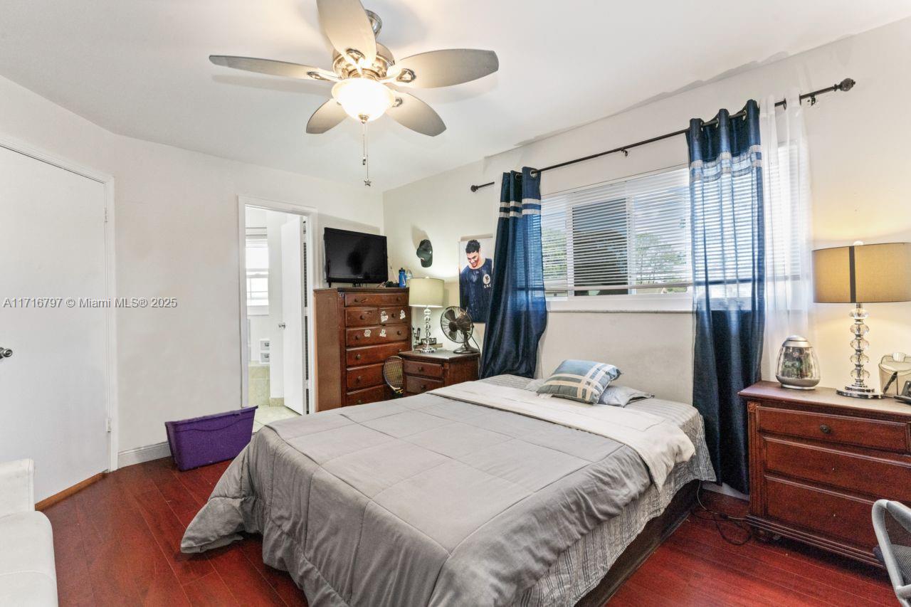 20929 Boca Ridge Drive West Boca Raton, FL 33428 - Photo 28 of 47 a bedroom with a bed a chandelier and a flat tv screen