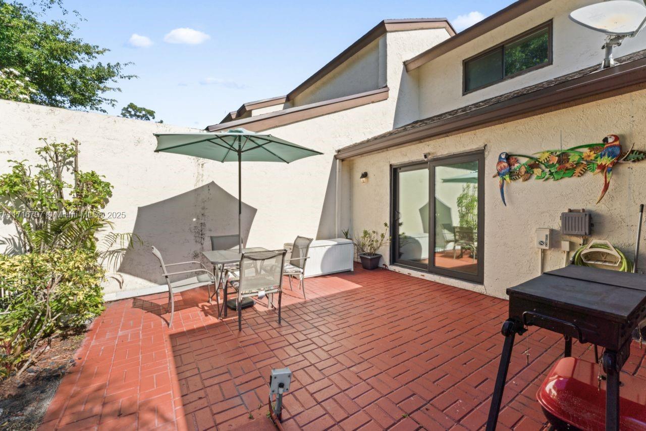 20929 Boca Ridge Drive West Boca Raton, FL 33428 - Photo 37 of 47 a view of a patio with a table and chairs under an umbrella