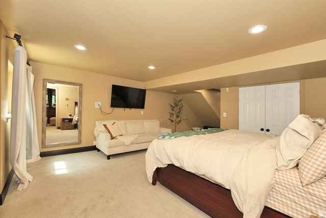 3104 East High Danish Road Sandy, UT 84093 - Photo 32 of 36 basement family room currently being used as primary bedroom.Carpeted room featuring recessed lighting, a built-in closet with bi-fold doors, and a wood-finish bed frame