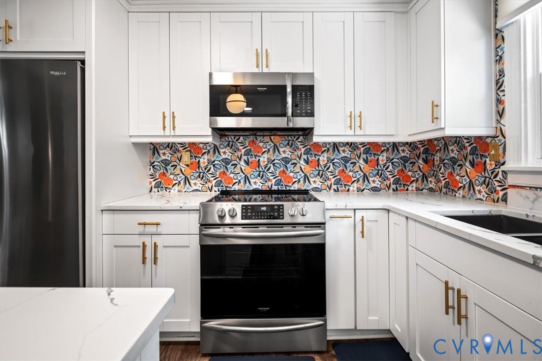 6805 Hermitage Road Henrico, VA 23228 - Photo 11 of 46 a kitchen with stainless steel appliances a stove a microwave and cabinets