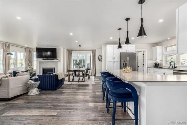 a kitchen with furniture wooden floor and a view of living room