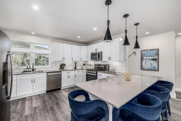 a kitchen with granite countertop white cabinets and stainless steel appliances