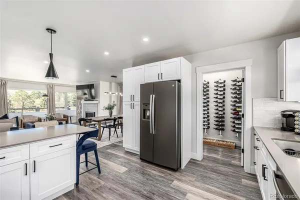 a kitchen with stainless steel appliances a refrigerator a sink dishwasher a stove and white cabinets with wooden floor