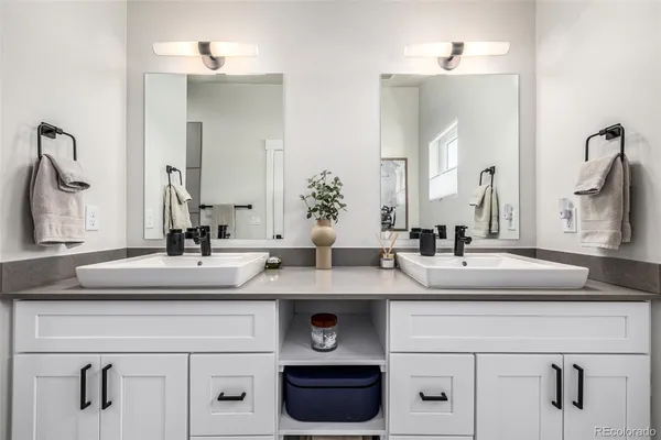 a spacious bathroom with a granite countertop sink mirror and shower