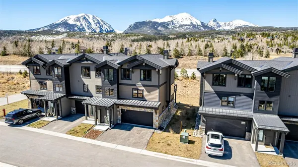an aerial view of a house with a mountain