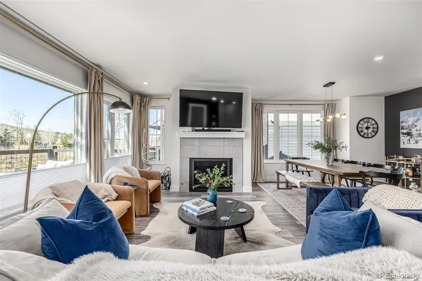 a living room with furniture a fireplace and a large window