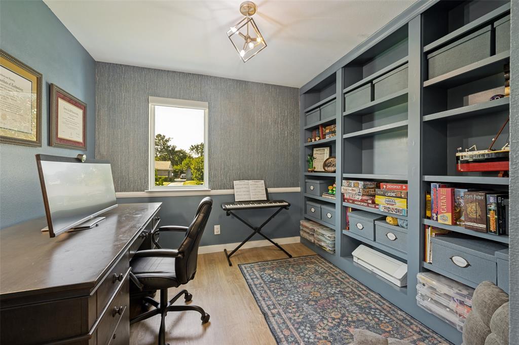 3619 Merrell Road Dallas, TX 75229 - Photo 12 of 26 Dedicated room featuring extensive built-in shelving, a large window, light wood-finish flooring, and a contemporary ceiling fixture
