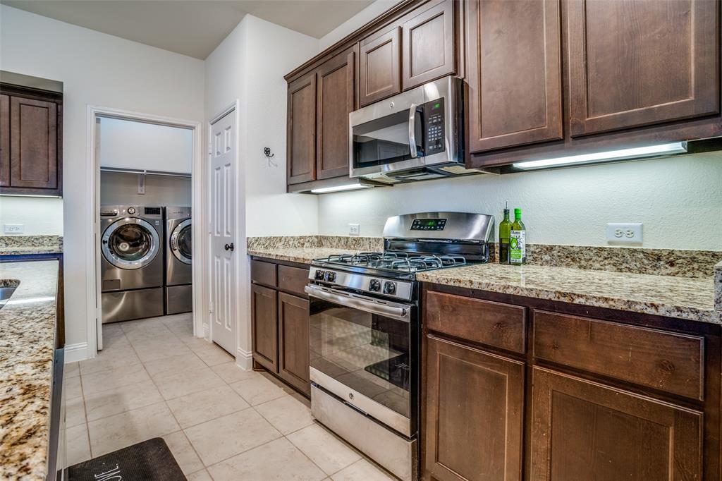 512 Barnstorm Drive Prosper, TX 75078 - Photo 8 of 25 a kitchen with granite countertop a stove top oven microwave and cabinets