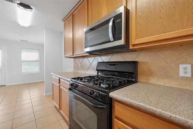 a kitchen with stainless steel appliances granite countertop a stove a microwave and a sink