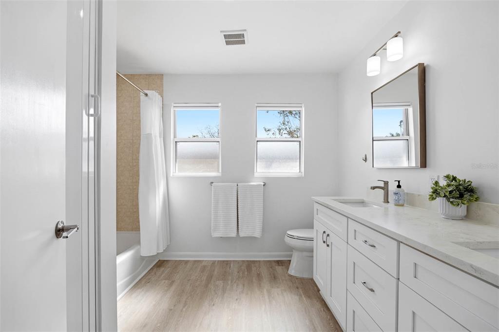 1218 Taylor Avenue Dunedin, FL 34698 - Photo 13 of 53 a bathroom with a double vanity sink toilet mirror and window