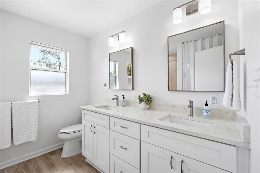 1218 Taylor Avenue Dunedin, FL 34698 - Photo 14 of 53 a bathroom with a toilet a sink a vanity and mirror