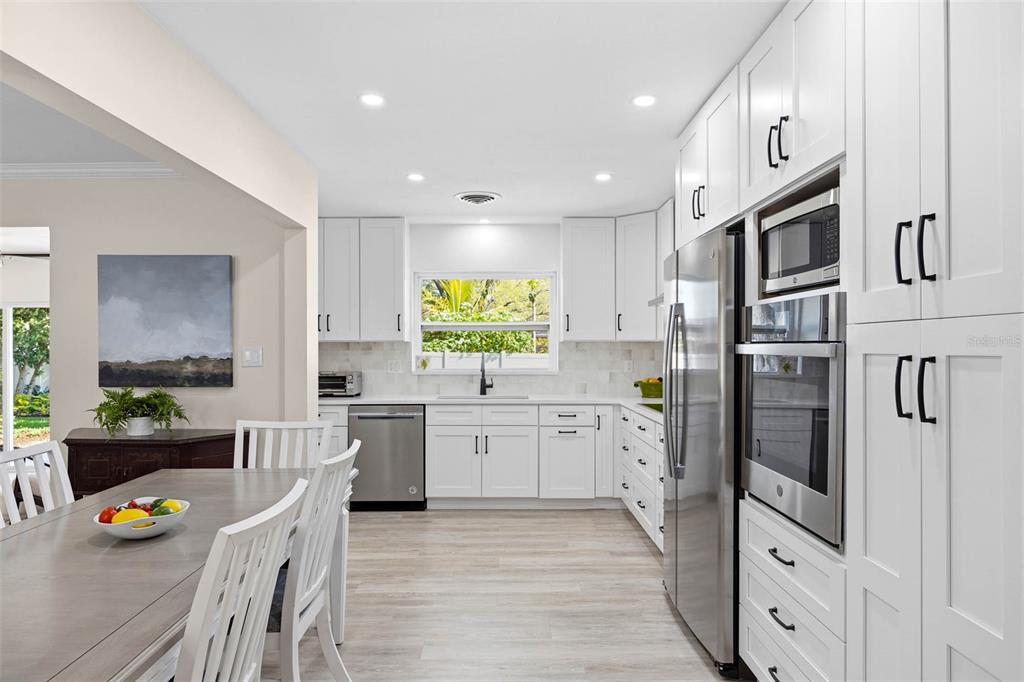 1218 Taylor Avenue Dunedin, FL 34698 - Photo 3 of 53 a kitchen with stainless steel appliances granite countertop a refrigerator and a stove top oven