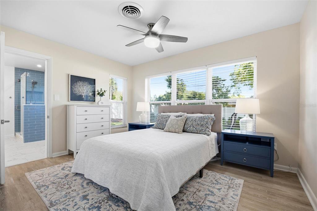 1218 Taylor Avenue Dunedin, FL 34698 - Photo 9 of 53 a bedroom with a large bed and a chandelier