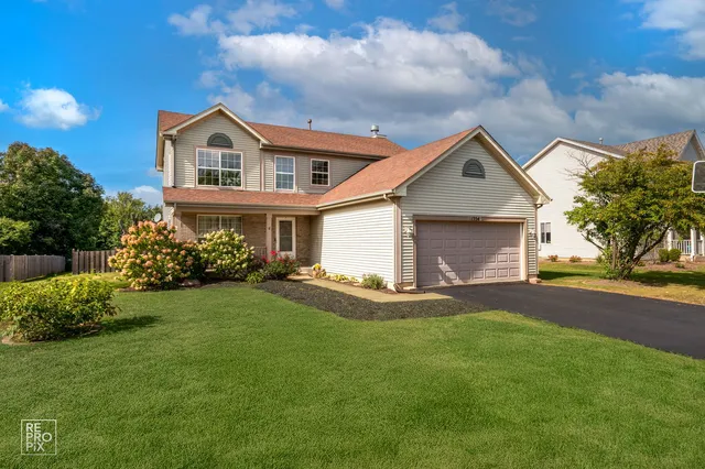 a front view of a house with a garden and yard
