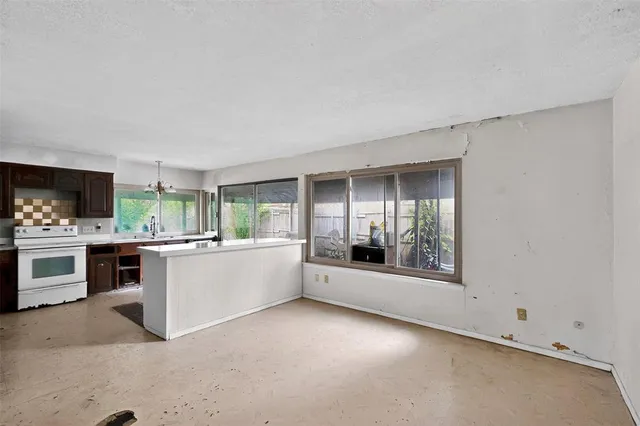 a large white kitchen with sink and cabinets