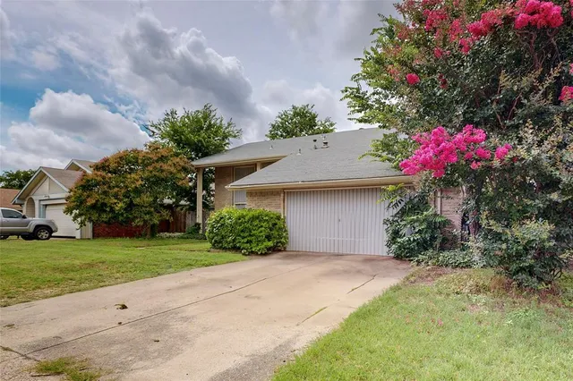 a front view of a house with a yard and a garage