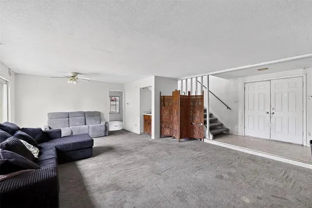 a living room with furniture and a ceiling fan