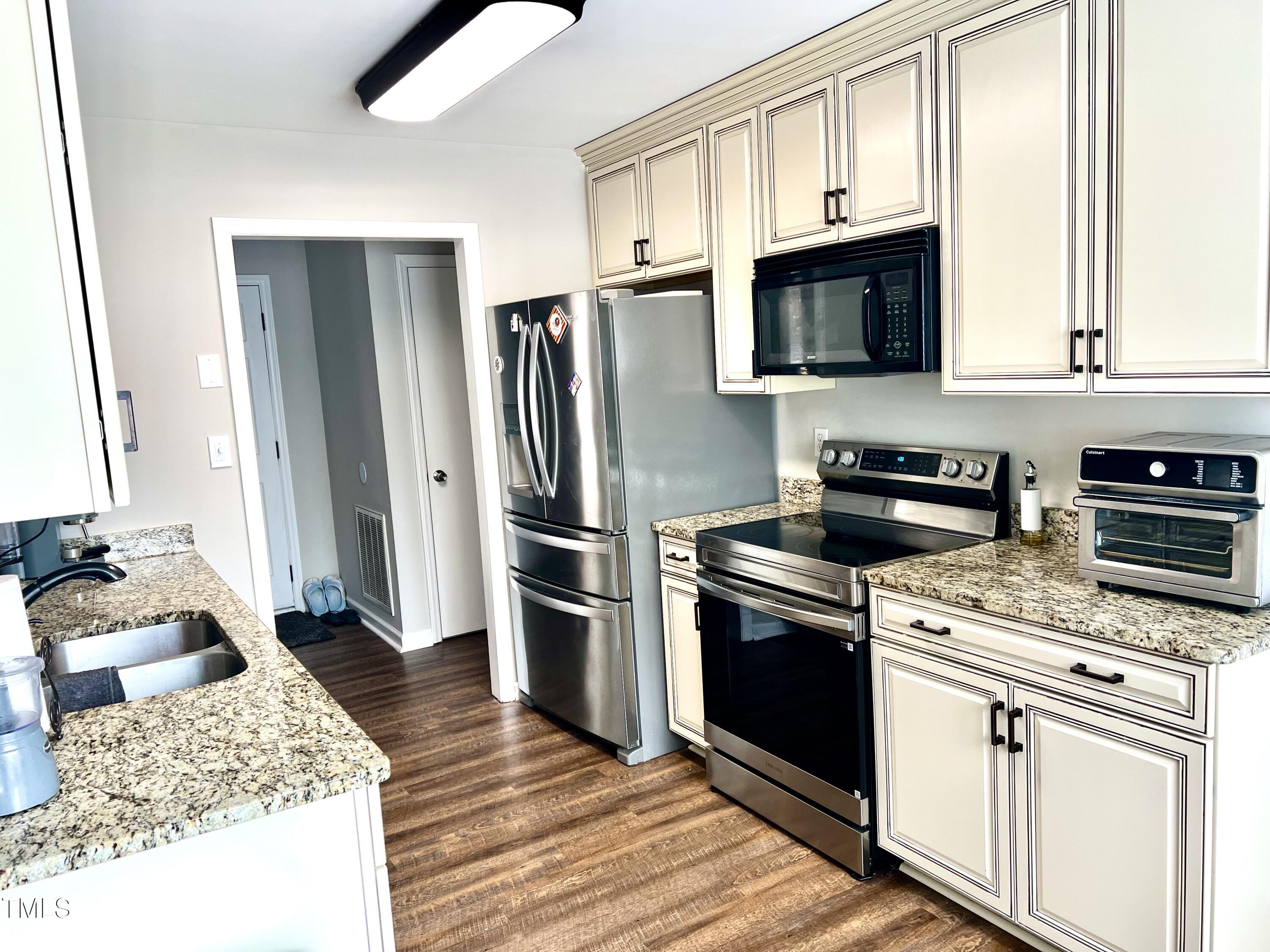 4216 Ferriday Court Raleigh, NC 27616 - Photo 15 of 29 a kitchen with stainless steel appliances granite countertop a refrigerator stove and sink