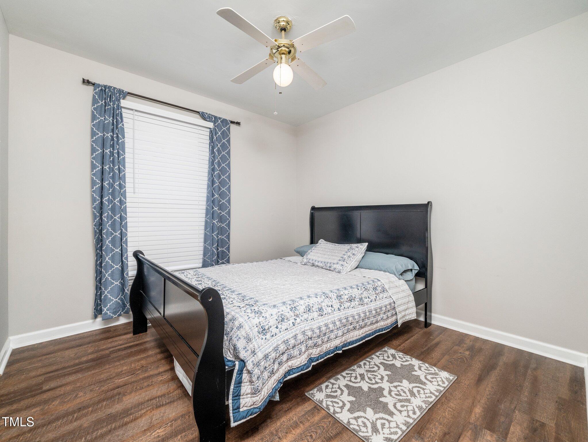 4216 Ferriday Court Raleigh, NC 27616 - Photo 21 of 29 a bedroom with a bed and wooden floor
