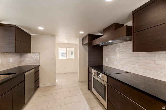 4658 Box Elder Street Salt Lake City, UT 84107 - Photo 9 of 17 Modern kitchen featuring dark wood-finish cabinetry, dark countertops, a white subway tile backsplash, stainless steel appliances, and recessed lighting