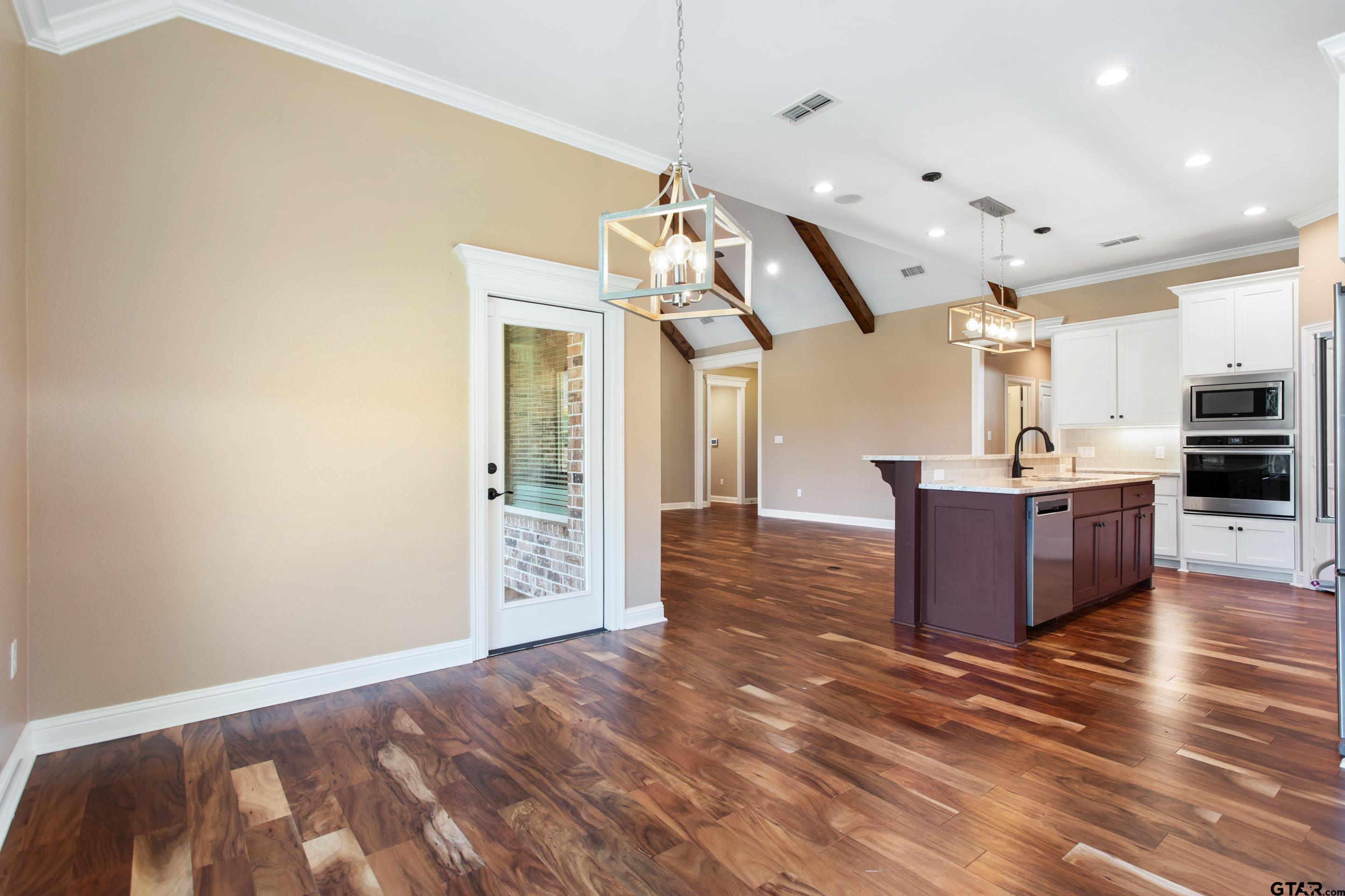 105 Nathan Road Chandler, TX 75758 - Photo 9 of 36 a view of a kitchen and kitchen island stainless steel appliances wooden floor and living room view